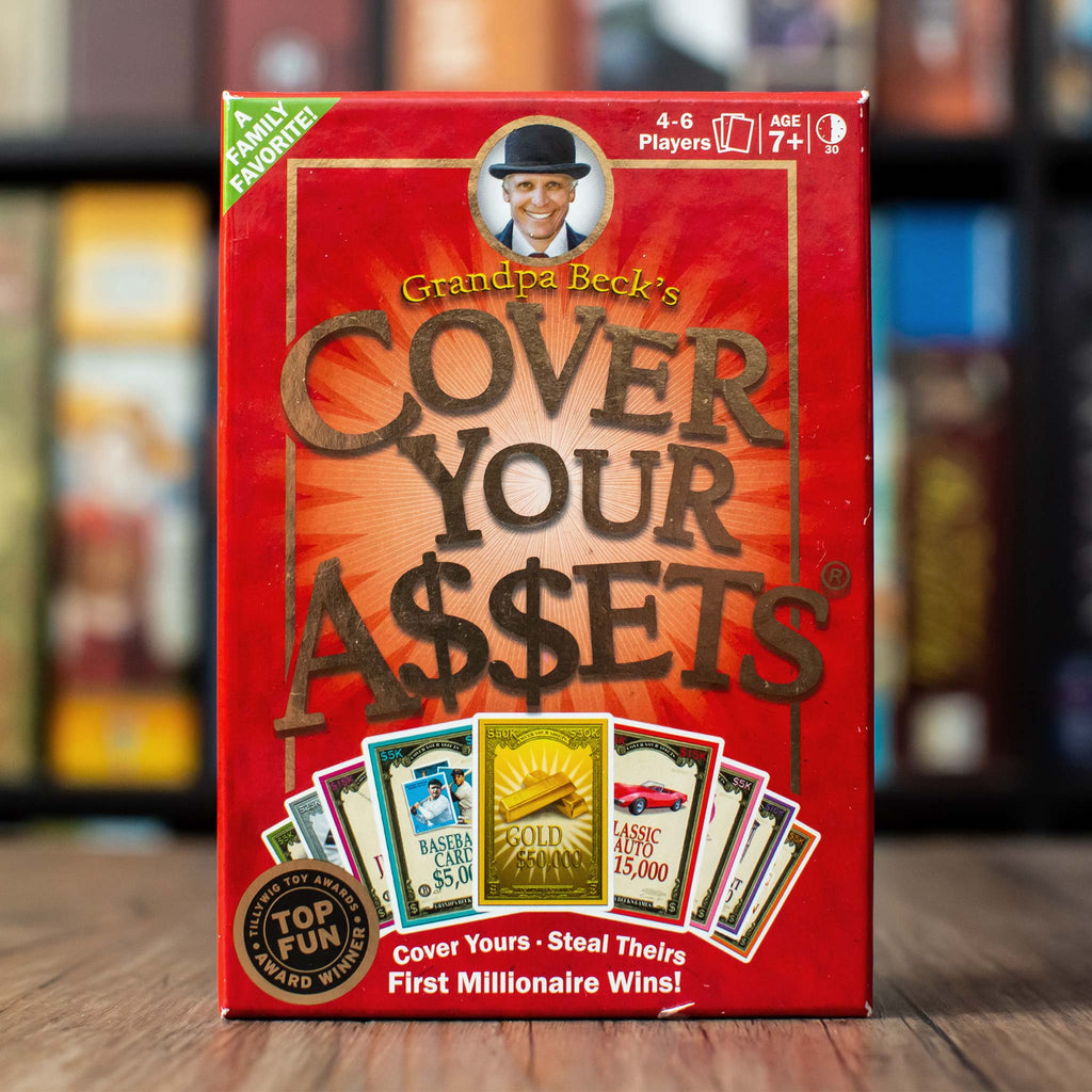 Portrait from the Front of Board Game Representing Cover Your Assets - Collector Edition at Grandpa Beck's Games